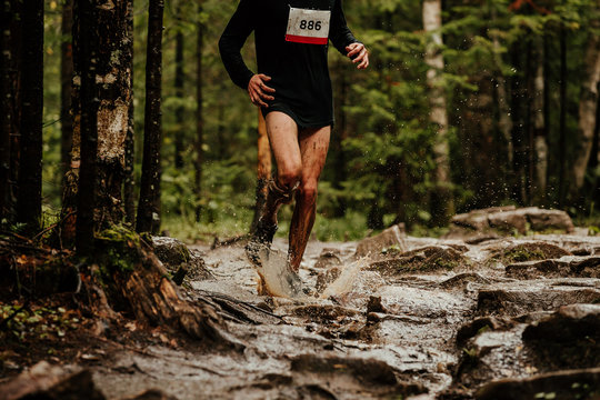 Athlete Runner With Dirty Legs Running On Puddle Of Water Spray