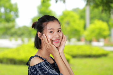 the face of young woman in bright background