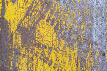 Worn yellow paint on metal sheet texture background