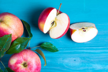 The cut apple lies on a wooden table next to the harvested fruit crop