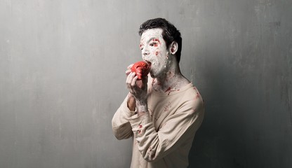 Terrorific zombie eating a heart.  Halloween holidays