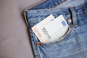 Moscow, Russia - 08 30 2018: Money financial concept. Hundred and fifty euro banknotes in a pocket of blue jeans on gray background.