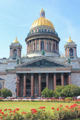Fototapeta na wymiar Saint Isaac's Cathedral in St. Petersburg, Russia. Church Facade Building Architecture View from Park Glade with Red Rose Flowers. Saint Isaac Cathedral City Attraction on Summer Day Background