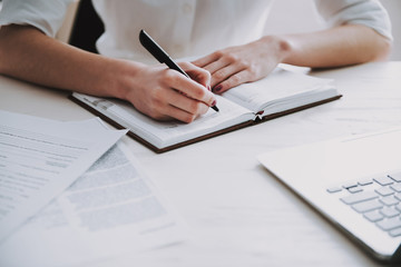 Closeup Young Business Woman making Notes at Work