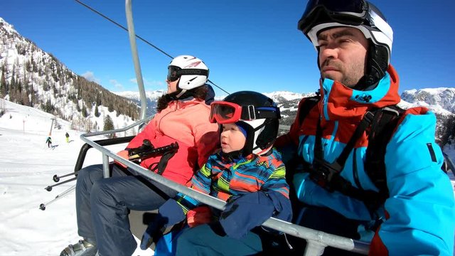Family on chairlift.
The boy and his parents rest on their way to the slopes. Stabilized footage.

