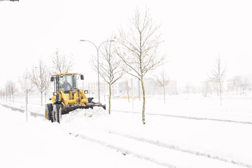 Snowplow cleaning a street in a city full of snow in winter
