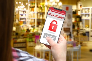 IP Blocked idea, girl with frameless phone on blurred shop background