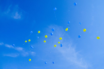 Festive multi-colored balloons in the blue sky