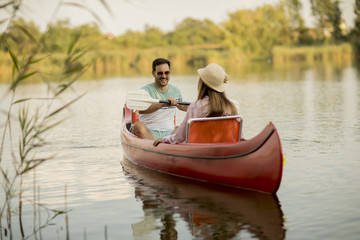 Fototapeta na wymiar Loving couple rowing on the lake