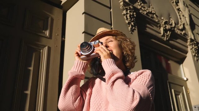 Woman Tourist Taking Photos With Vintage Camera While Sightseeing In City