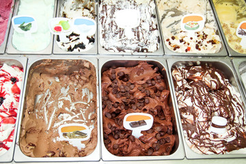 Ice cream fridge with creamy and fruit Italian ice cream steel serving counter with many of refreshing sweet scoopable flavors. Ice cream display, various flavors of gelato ice cream. Pastry shop.