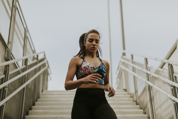 Young woman running alone down the stairs