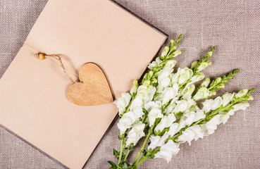 bouquet and heart. Wooden heart and white flowers. St. Valentine's Day. Open book. Romantic background