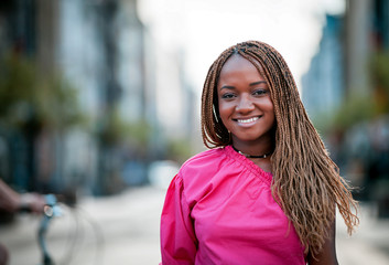 Beautiful smiling African girl walking in the city street