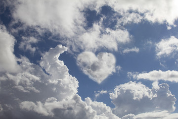 Blue sky on sunny day with clouds forming a big heart