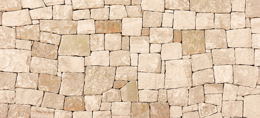 Masonry wall of stones with irregular pattern texture background