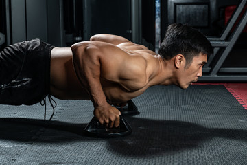 Asian people work out by push-up the floor in  modern gym.