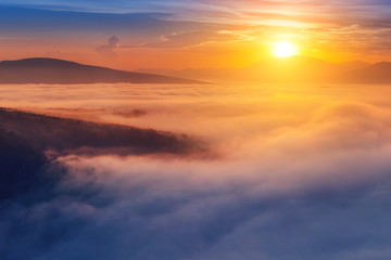 Colorful landscape in mountains with fog and sun