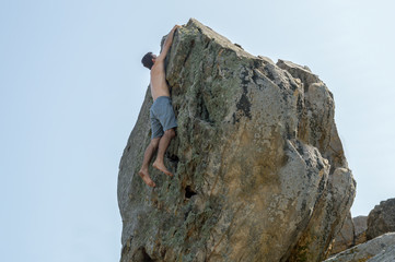 A man climbs up the rock mountain, climbing