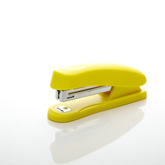 Yellow stapler on the white