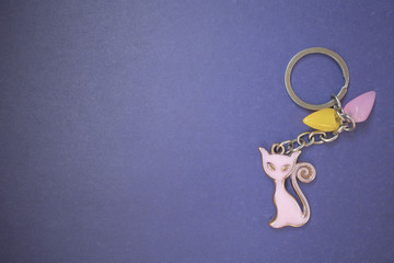 Fototapeta na wymiar keychain with a pink cat on a purple background, copy space, a place for advertising