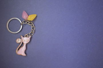 keychain with a pink cat on a purple background, copy space, a place for advertising