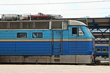 a large blue locomotive stands at the station on the railway
