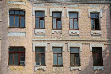 row of old windows on a brick brown building wall