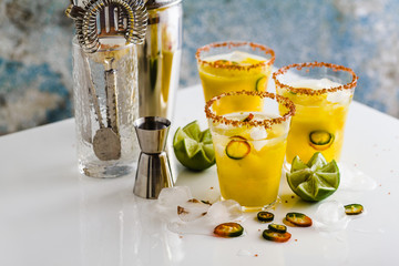 cocktail margarita of tequila, mango juice, hot pepper and lime on the table. bar accessories