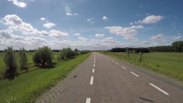 POV driving on polder dike near river Rhine in Holland between Amerongen and Wijk bij Duurstede backwards view