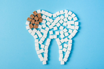 Sugar destroys the tooth enamel and leads to tooth decay. Tooth made of white and caries made of...