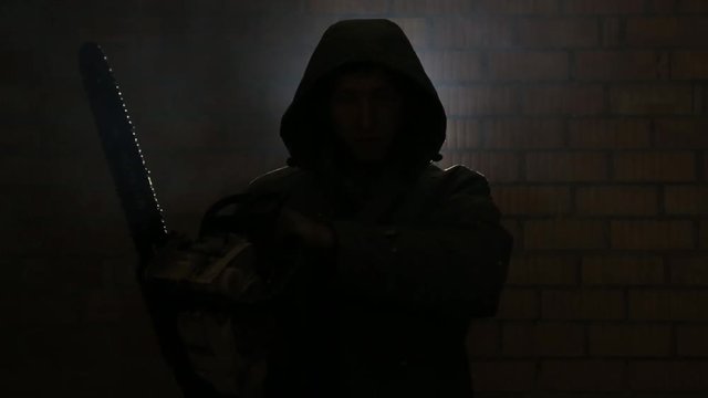 Maniac with a chainsaw breathing heavily waiting for his victim