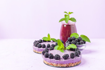Raw blackberry dessert decorated with fresh ripe forest berries and green mint leaves and blended...