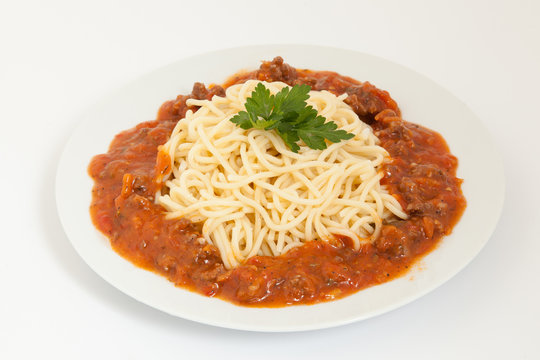 Spaghetti bolognese decorated with leaf on a white plate