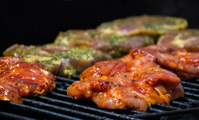 Some pieces of marinated meat on a grill 