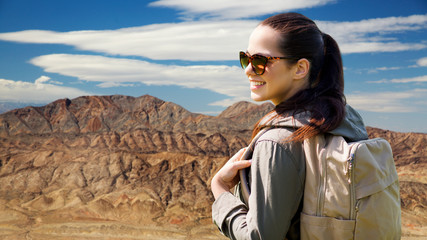 adventure, travel, tourism, hike and people concept - smiling young woman with backpack over grand canyon national park background