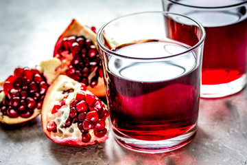 pomegranate juice with seed on stone table background