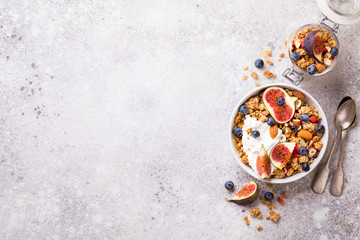 Muesli with Nuts Yogurt and fresh Figs Blueberry on the gray Background.Granola Healthy Breakfast. Sweet food Dessert. Snack  Dry Diet Nutrition Concept.Top View. Flat Lay.Copy space for Text