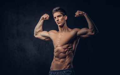 Handsome shirtless man with stylish hair and muscular ectomorph shows his biceps.