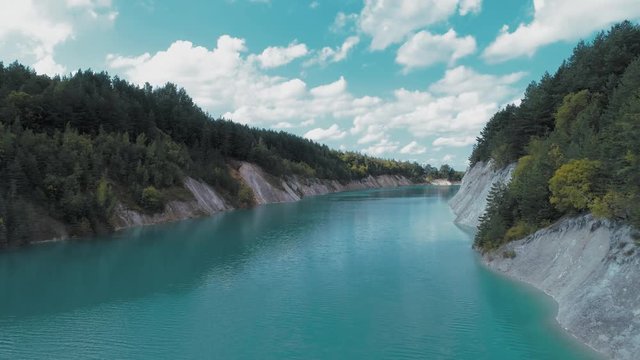 An abandoned plaster pit filled with blue water.