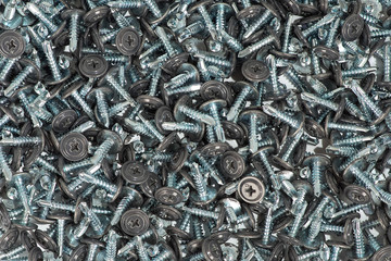 background of a many gray screws scattered on a table