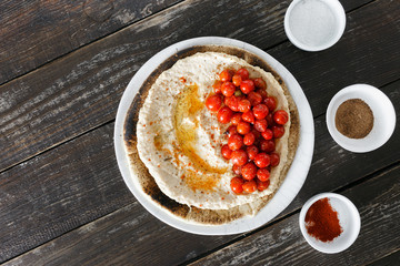 Chickpea hummus served flatbread cherry tomatoes wooden table top view