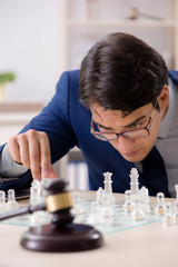Young lawyer playing chess to train his court strategy and tacti