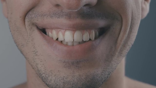 Close up of smiling teeth isolated on white background. Detail of a smile man. Young woman smiling on white background.