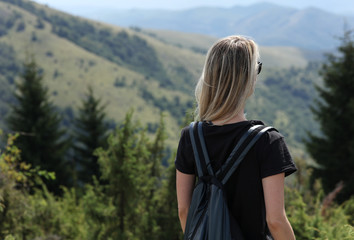 Young woman enjoying mountain view, relaxing, walking in nature. Solo traveller concept