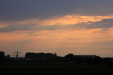 Electricity pylons in the sunset photographed in Germany at the end of a hot summer day
