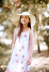 a girl walks along a forest path, dressed in a long dress and wide hat, bright sun and shadows, a beautiful summer day