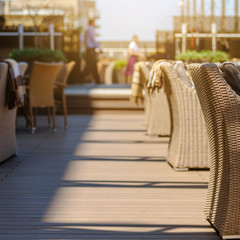 Interior of summer terrace with wicker furniture in modern restaurant