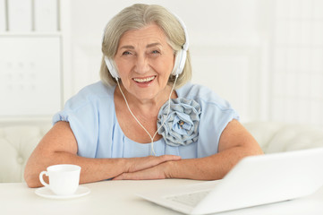 Portrait of senior woman in headphones at home