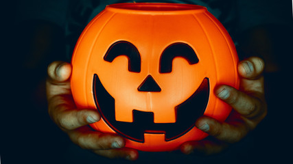 Hand holding a pumpkin of halloween baubles